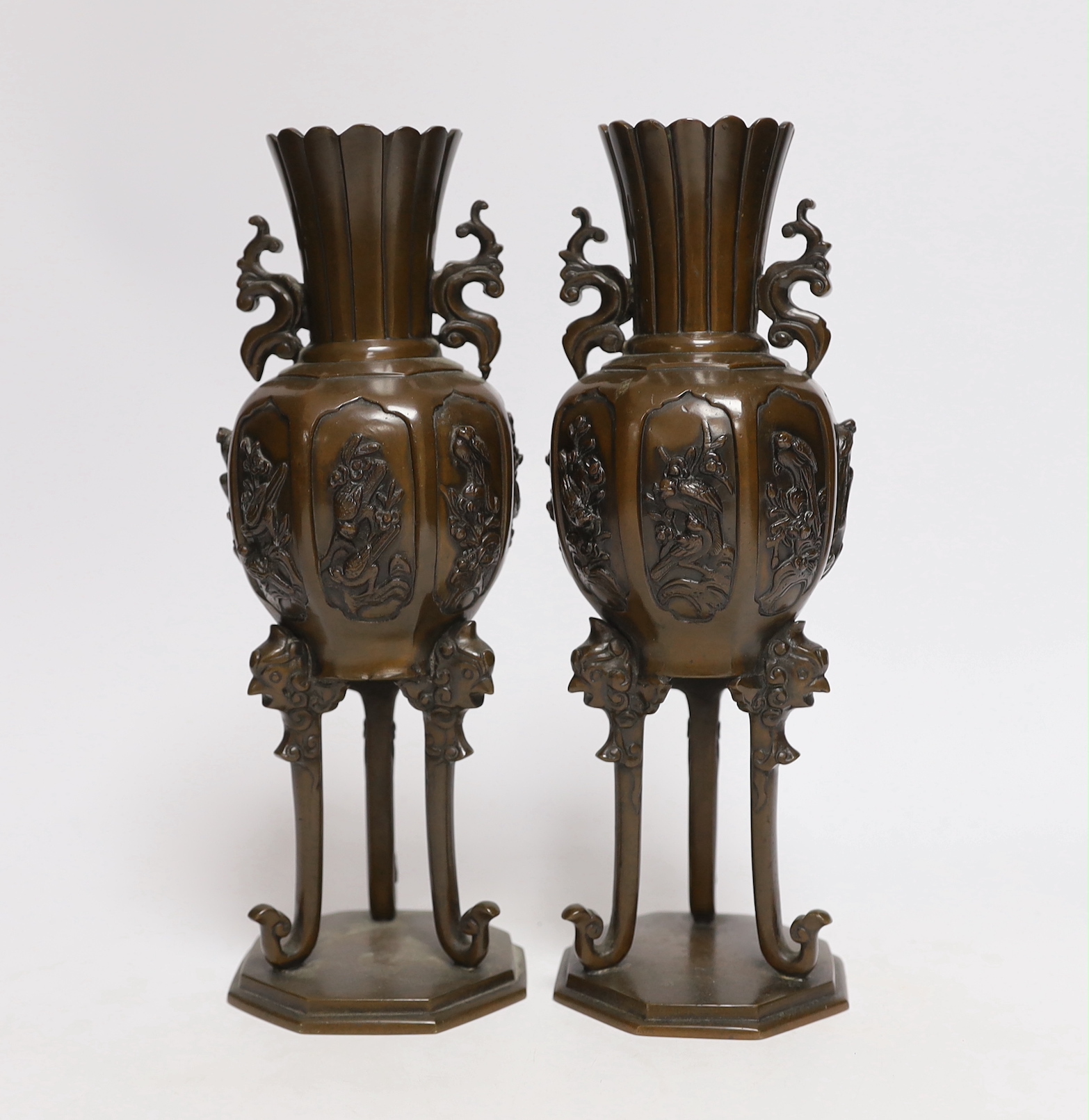 A pair of Japanese bronze vases on tripod legs, 24.5cm